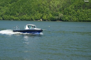 łódka policyjna na jeziorze w tle góry