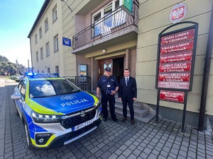 radiowóz zaparkowany przed urzędem gminy w łekawicy przed radiowozem stoją policjanci oraz wójt