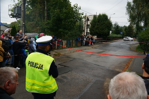 policjant stoi tyłem obok widzowie w tle trasa rajdu