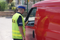 zdjęcie kolorowe poglądowe policjant podczas sprawdzania staniu trzeźwości kierowcy