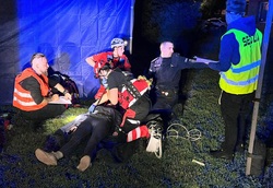 zdjęcie kolorowe zrobione w nocy policjant i uczestnicy ćwiczeń podczas ćwiczenia