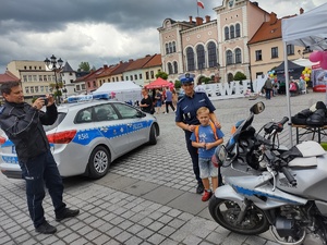 kolorowe zdjęcie policyjnego motocykla policjantki policjanta i dziecka