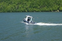 zdjęcie kolorowe policyjna motorówka pływa na jeziorze