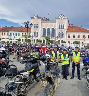 zdjęcie kolorowe policjanci na rynku naokoło nich motory