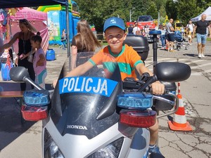 chłopczyk siedzi na policyjnym motocyklu