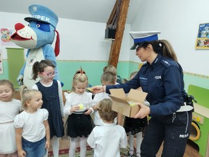 policjantka rozdaje dzieciom odblaski