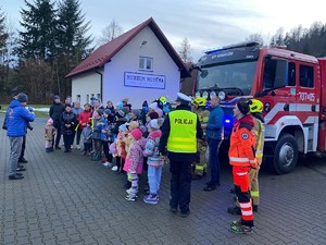 zdjęcie kolorowe policjanci i organizatorzy rozdają odblaski