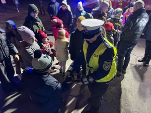 zdjęcie kolorowe, policjantka rozdaje odblaski