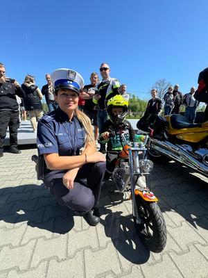 policjantka obok chłopczyka który siedzi na motorze