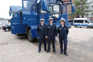 Kadeci z Niemiec w katowicki oddziale prewencji. 
Przyszli niemieccy policjanci pozują do zdjęcia na tle miotacza wody.