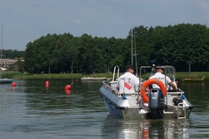 Policjanci patrolują jezioro na łodzi motorowej