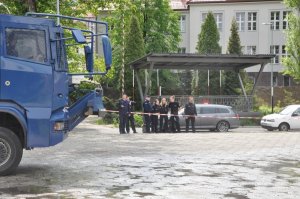 na pierwszym planie policyjna armatka wodna natomiast w tle obserwujący ćwiczenia umundurowani policjanci z Polski i Niemiec
