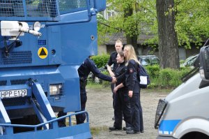 zdjęcie przedstawia umundurowanych policjantów z Polski i Niemiec. Polski stróż prawa podaje dłoń niemieckiej policjantce