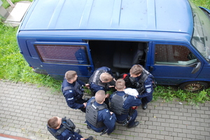 Policjanci uczestniczący w konkurencji ratownictwa medycznego, którzy symulują wyciąganie osoby poszkodowanej z pojazdu.