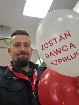 Podkom. Mateusz Derela z balonem z napisem &quot;zostań dawcą szpiku&quot;.