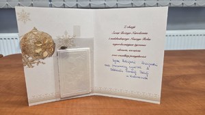 Kartka z życzeniami świątecznymi i opłatkiem od policjantów i pracowników OPP w Katowicach.