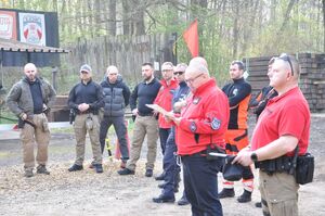 Główny sędzia zawodów przemawia podczas otwarcia. W tle pozostali sędziowie.
