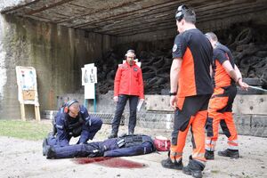 Sędziowie zawodów - ratownicy medyczni oceniają udzielanie pomocy rannemu policjantowi (manekin).